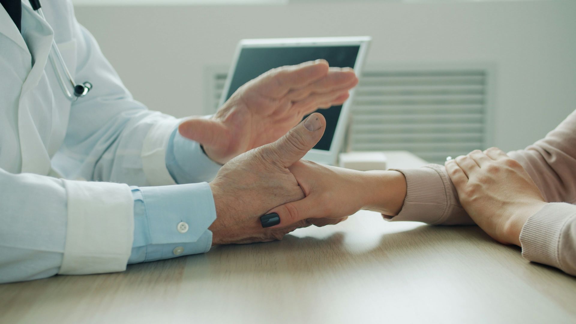 Doctor comforting patient with a hand on arm